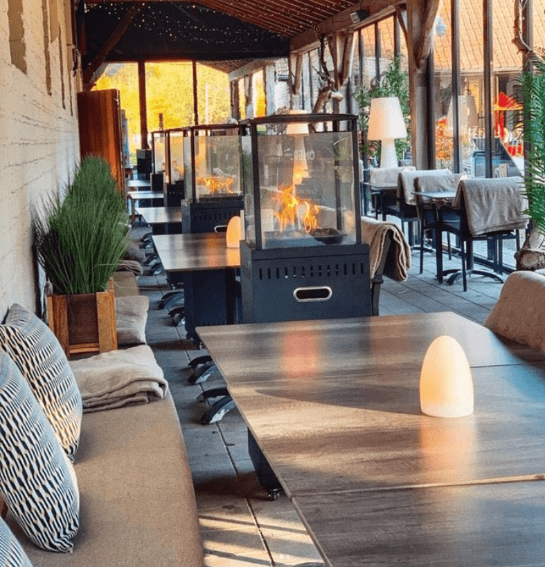Het terras van Brasserie Rhodesgoed onder de bomen